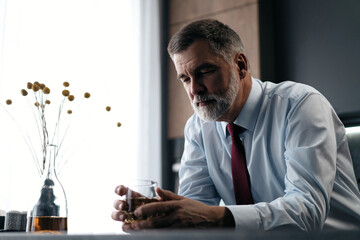 Confident rich mature wealthy businessman chilling relaxing drinking enjoying whiskey in the...