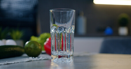 Close up of transparent glass which is poured with mineral water with bubbles in the modern cuisine