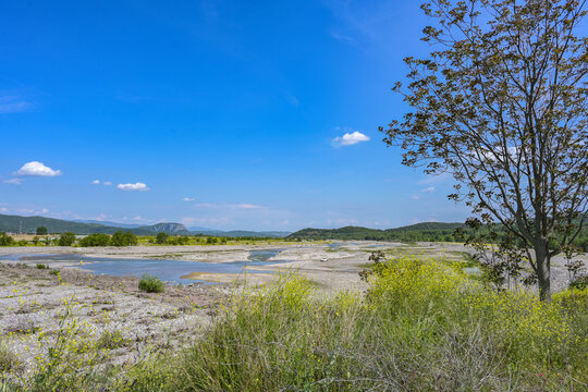 Dried Up Riverbed Of The Pinios Near Kalambaka In Thessaly, Greece, Low Water After Heat And Drought, Potential Effect Of Global Climate Warming, Wide Landscape Under A Blue Sky, Copy Space