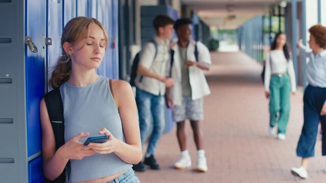 Unhappy female high school or secondary student being teased and bullied by boys outside classroom with teacher intervening to help her- shot in slow motion 