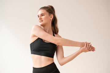 Obraz premium Young woman dressed in sportswear doing fitness exercises at home