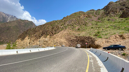View of a mountain paved road and several parked cars. Amazing mountain landscape. Panorama of the valley. Beautiful nature