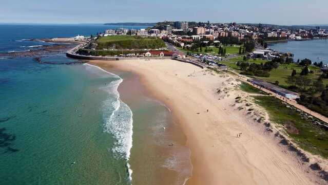 Aerial drone shot of Nobbys Beach Newcastle Pacific Ocean beautiful day sandy beach travel tourism buildings town CBD NSW Australia 4K