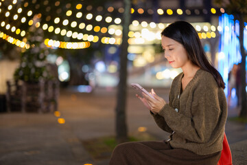 Obraz premium Woman use mobile phone in city at night