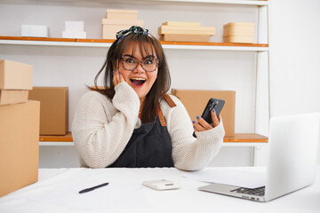 Expression happy small business owner having an online meeting in a warehouse. Cheerful businesswoman running an online startup.