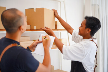 Photo of small business owners pack up in card boxes at work. Prepares packages for delivery at the office of an online sales business.