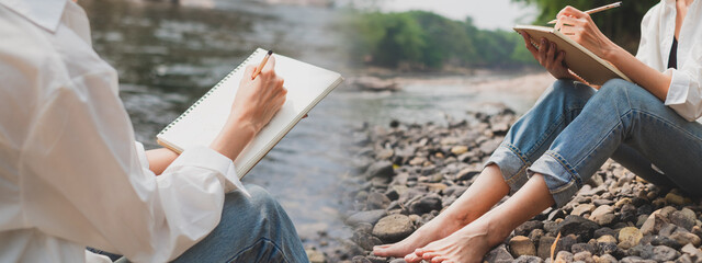 A female is drawing, drafting and sketching an idea while sitting beside and relaxing beside the river. Concept of artist dreaming, imagination, peaceful and inspiration outdoor working or painting.