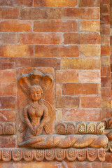 Bas-relief of a half woman half snake on the wall of a Hindu temple in Pokhara, Nepal.