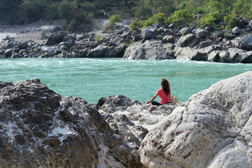 A girl meditates on the banks of the Ganges River in Rishikesh, India.