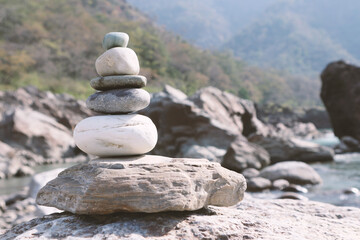 Pyramid of pebbles on the banks of the Ganges in Rishikesh, India. Meditation concept, calming the mind, contemplation and balance.