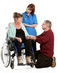 Fototapeta na wymiar Health Professionals: Patient Care. A senior patient in a wheelchair receiving support from her partner and a nurse. From a series of related images.