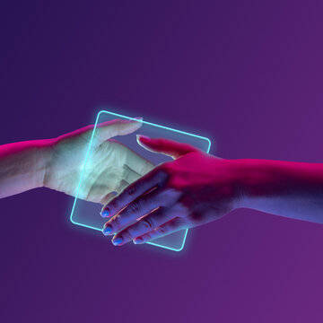Portrait with human hands shaking hands near glowing square over minimal purple background in neon light. Cooperation and partnership