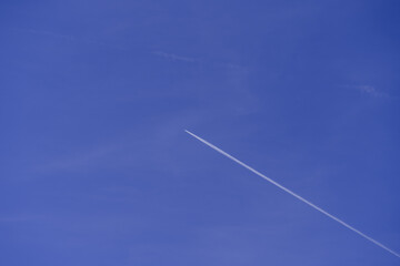 Lonely contrail of jet aircraft in blue sky without clouds, minimalistic natural sky background, aircraft flying high in the sky, cruise missile strikes, azure sky. copy space