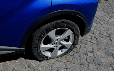 torn tire with holes in the side. the police chase ended with flat tires. rubber scratches and a...