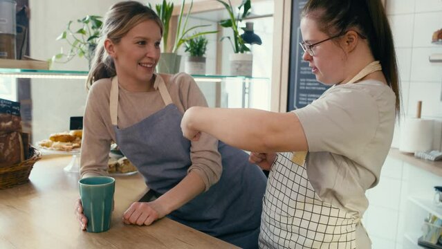 Down syndrome girl chatting with her workmate in the cafe. Shot with RED helium camera in 8K.  