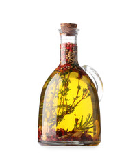 Glass jug of cooking oil with spices and herbs isolated on white