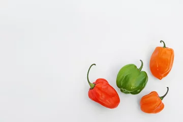 Rolgordijnen Different hot chili peppers on white background, flat lay. Space for text © New Africa