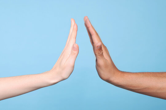 International relationships. People giving high five on light blue background, closeup