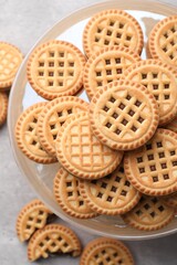 Tasty sandwich cookies with cream on grey table, flat lay