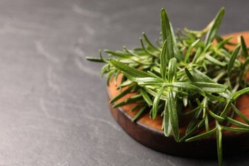 Fresh green rosemary on grey table, closeup. Space for text