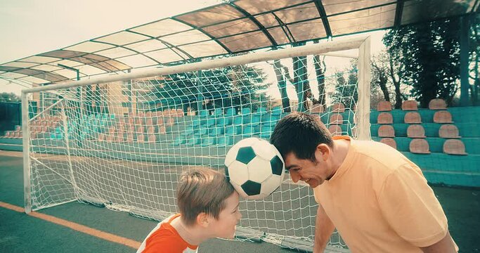 father's day, Father and Son play football on stadium, Happy family outdoors, bonding, family fun, players in soccer in dynamic action have fun playing football in fathers day, holidays time.
