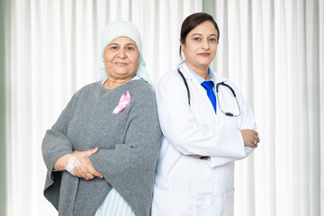 Portrait of indian senior woman cancer patient and doctor do standing cross arms at hospital,...