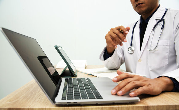 Medicine doctor in medical uniform working with computer notebook at desk in the hospital