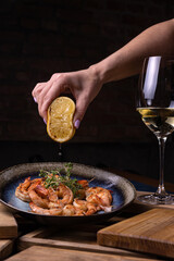 A bowl of shrimp with lemon on the side