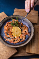 A bowl of shrimp with lemon on the side