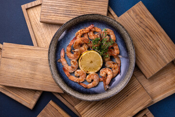 A bowl of shrimp with lemon on the side