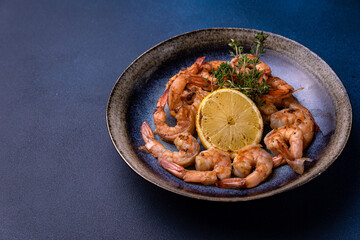 A bowl of shrimp with lemon on the side