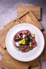 A salad with a piece of meat and cheese