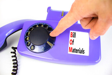 BOM bill of materials symbol. Concept words BOM bill of materials on beautiful old disk phone. Businessman hand. Beautiful white background. Business and BOM bill of materials concept. Copy space.