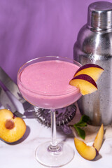 Sweet summer cold plum daiquiri or martini cocktail, liquor with red plum slices,crushed ice and...