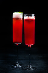 Pomegranate carbonated cocktail with mint in glasses on a black.
