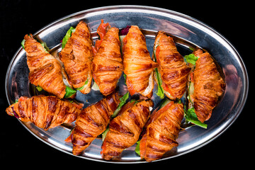 Fresh croissants with salmon, cucumber, cream cheese and lettuce.