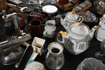 Many different stuff on black wooden table. Garage sale