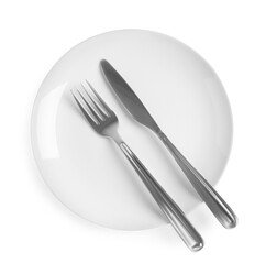 Ceramic plate, fork and knife on white background, top view