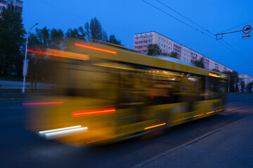 Fototapeta na wymiar Blurred bus movement down the street in the evening.