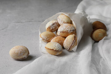 Delicious walnut shaped cookies with condensed milk on grey table, closeup