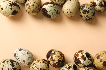 Many speckled quail eggs on beige background, flat lay. Space for text