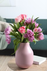 Beautiful bouquet of colorful tulip flowers on coffee table in room