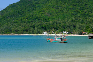 Fototapeta na wymiar Fishing Boat in Blue Sea: Fishing to Tropical Paradise
