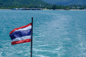 Journey through Thai Waters: Ship's View of an Thailand Flag and Blurred Island