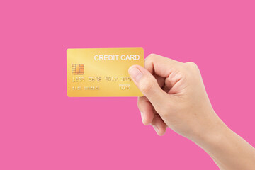 Female hand holding credit card on pink background