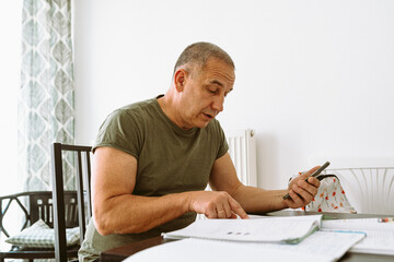 middle-aged man writes notes in notebook