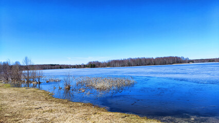 Landscape with a lake covered with ice before the start of melting and ice drift on a spring day...