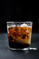 Cocktail White Russian in a glass with cream.