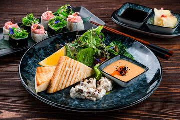 Japanese food fresh green salad with lemon, fried bread, sauce and sushi roll set.