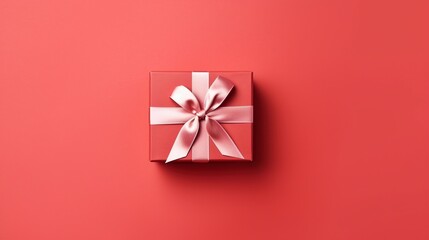 Gift box with  satin ribbon and bow on red background. Holiday gift with copy space. Birthday or Christmas present, flat lay, top view. Christmas giftbox concept.